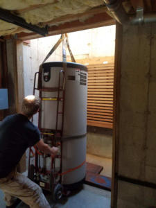 Guiding the heater as it is lowered into the utility basement.